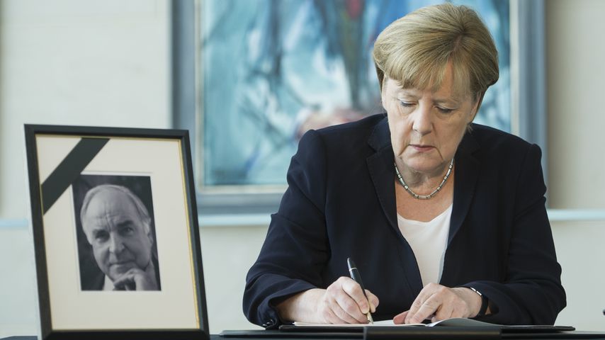 Angela Merkel mit einem Bild von Helmut Kohl