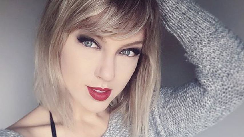 April Gloria als Taylor Swift im grauen Pullover