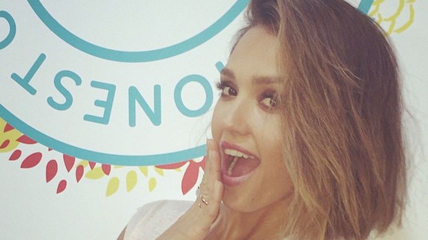Jessica Alba vor dem Logo ihrer Firma The Honest Company