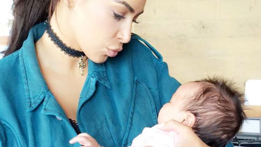 Kim Kardashian mit dem Baby von Chrissy Teigen