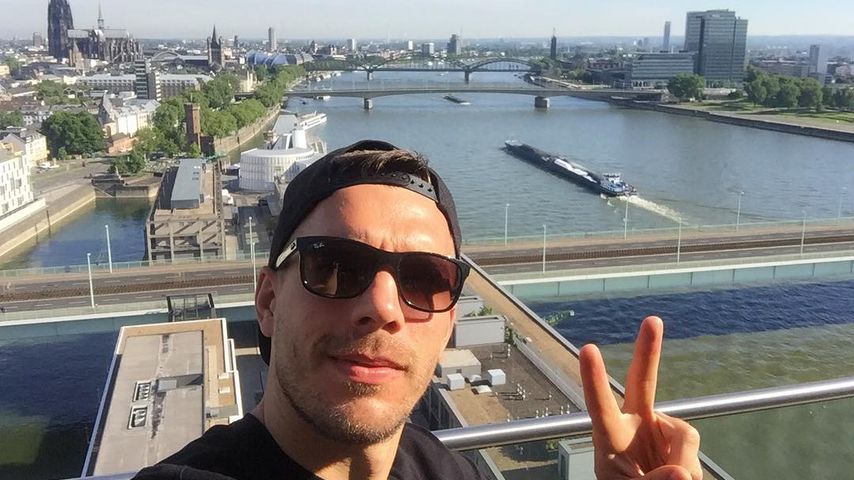 Lukas Podolski vor der Kölner Skyline